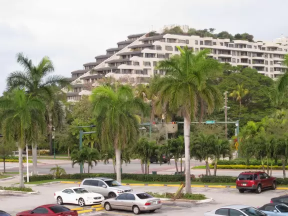 Picturesque beach with white lighthouse, happy people, and turquoise water.