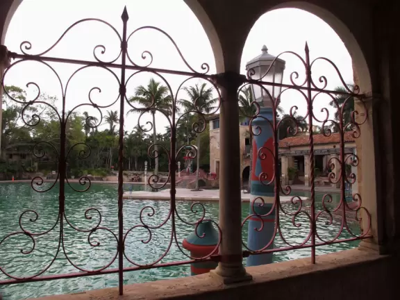 Unique spring-fed historical pool with Venetian-style buildings, bridge, striped posts, waterfall, caves, palms, and banyan tree. Glorious!