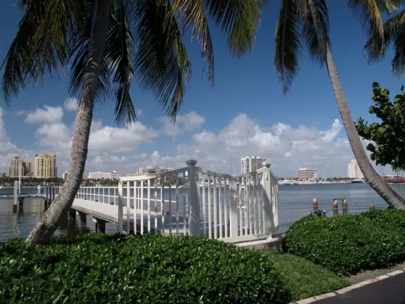 A cement bike and walking path along the intercoastal waterway in front of mansions and past glorious trees.